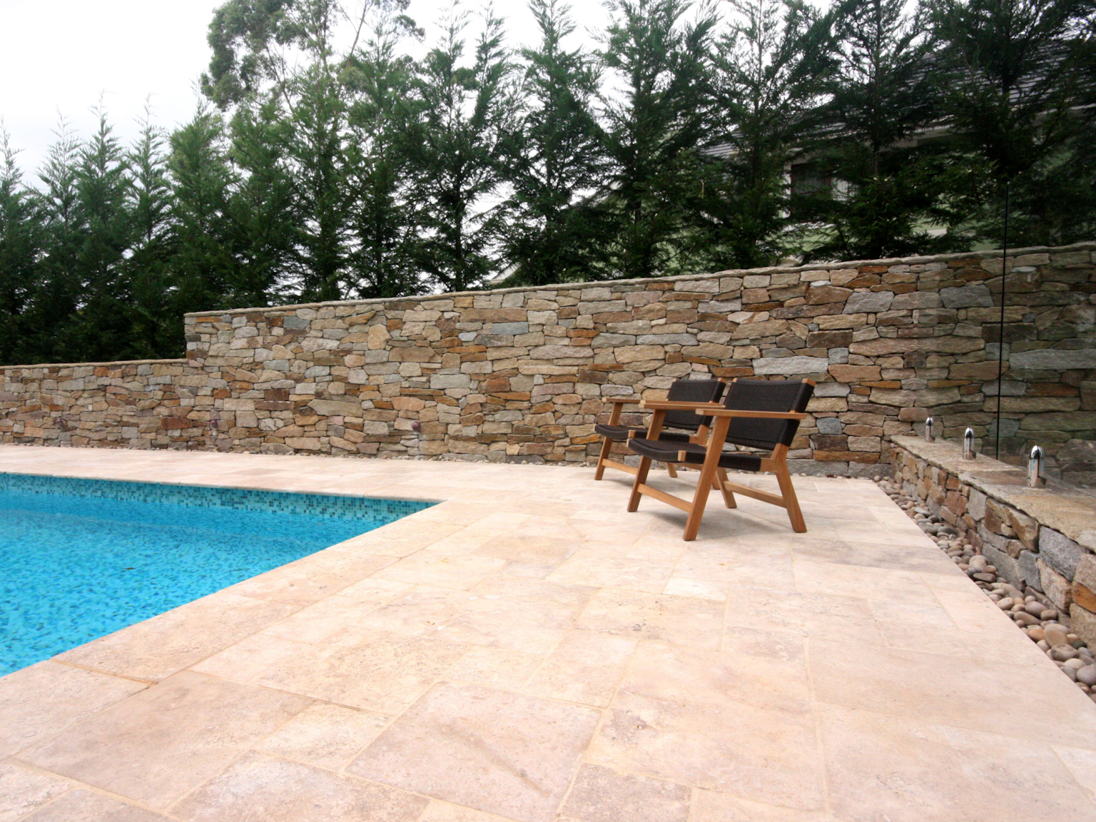 Capri travertine pool coping and paving with Alpine dry stone walling