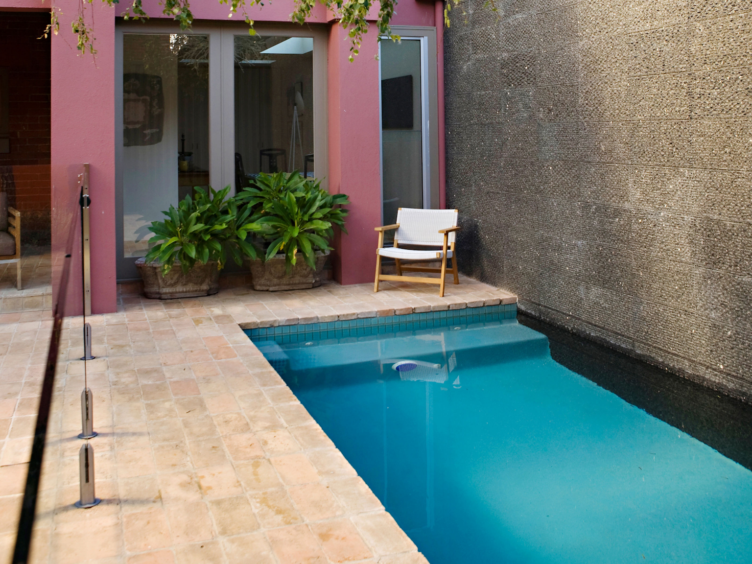 Antico Luce cotto coping units and rough sycled Raven granite walling in pool area