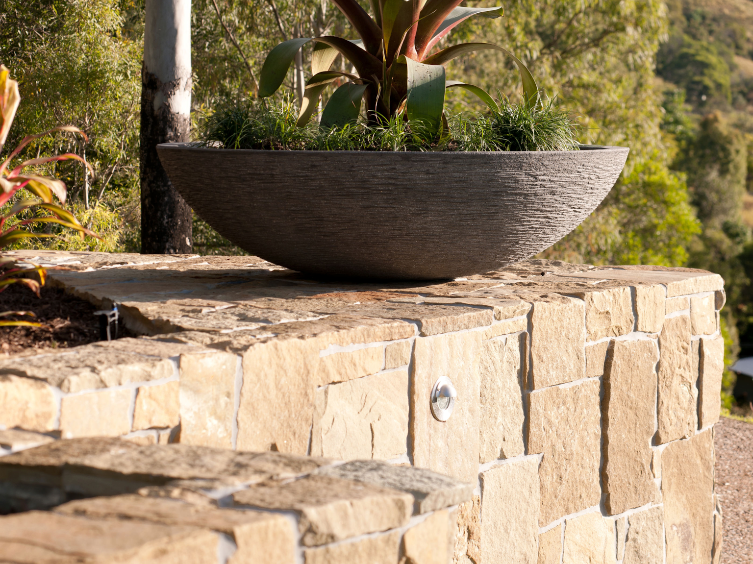 Clancy sandstone random ashlar retaining wall with planter on top
