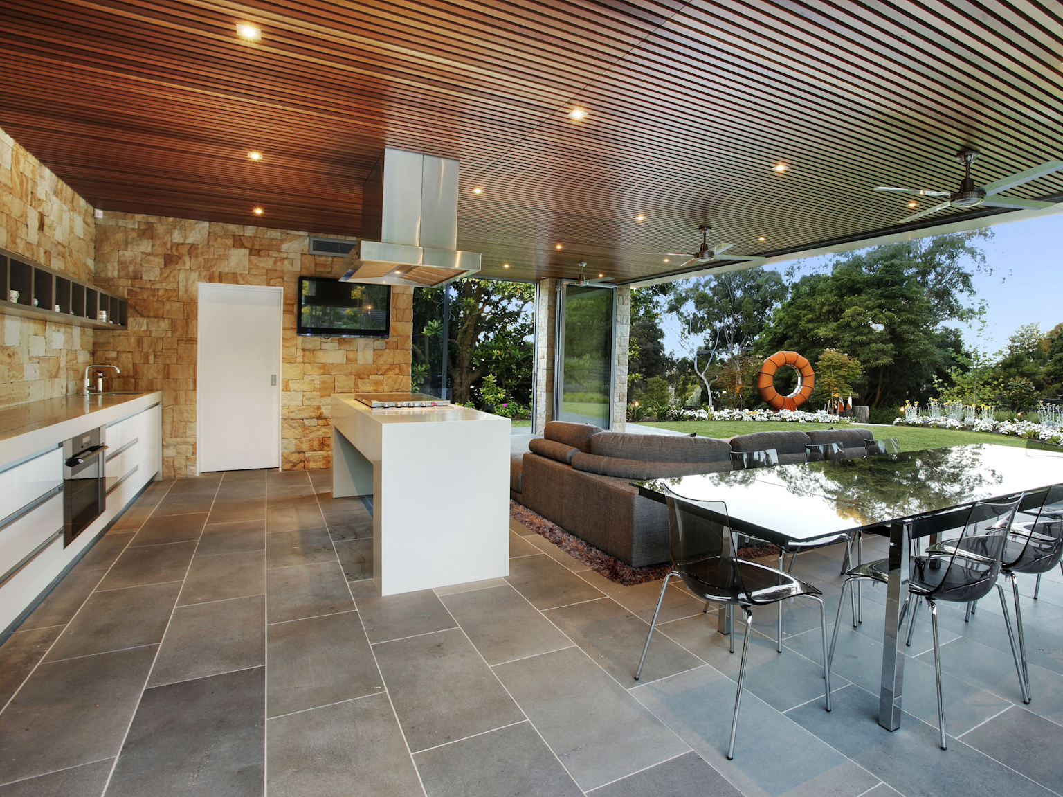 Outdoor kitchen area with large format bluestone paving and Killcare sandstone random ashlar walling
