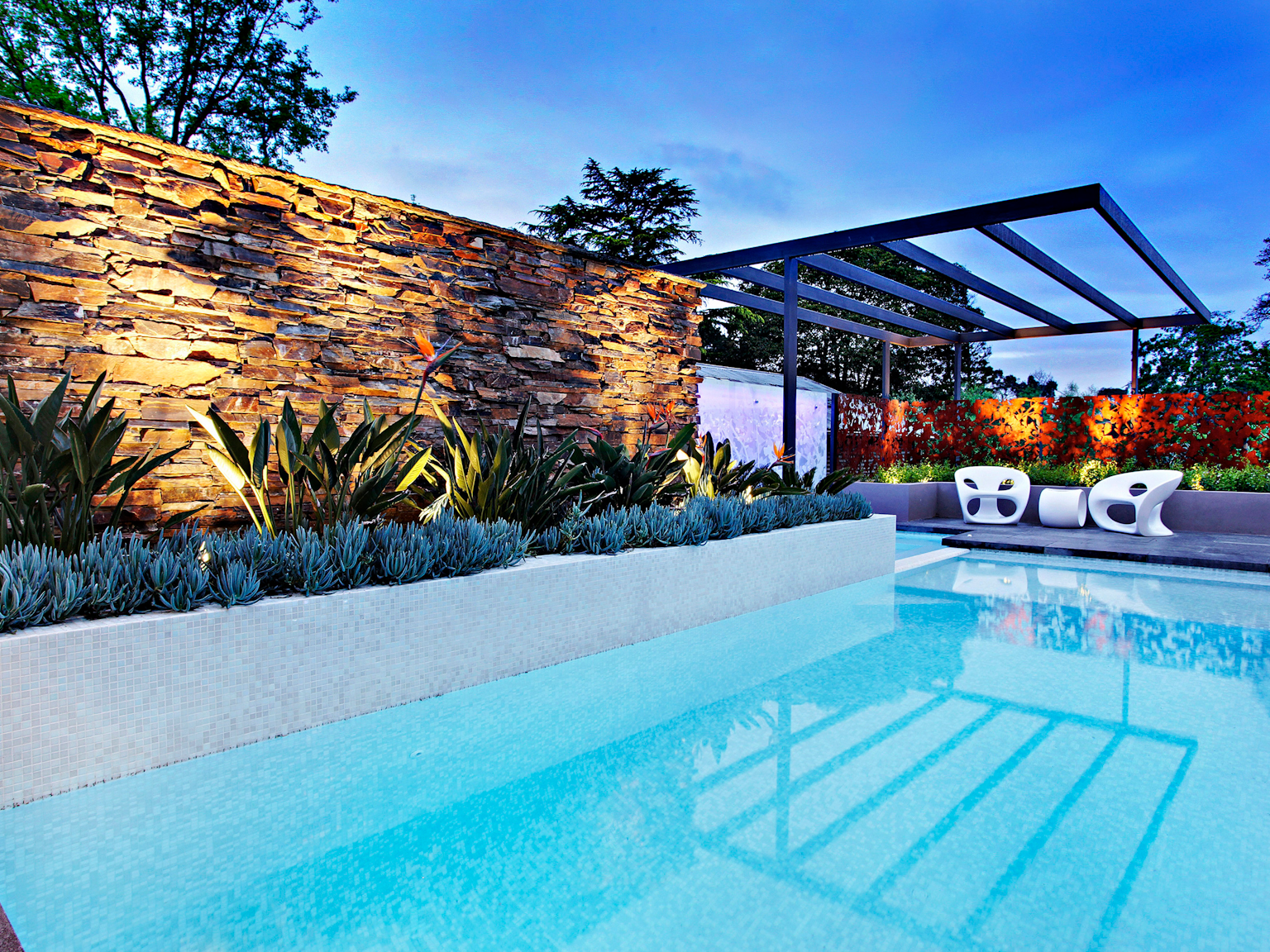 Contemporary pool design with Badger dry stone feature wall and bluestone pool coping