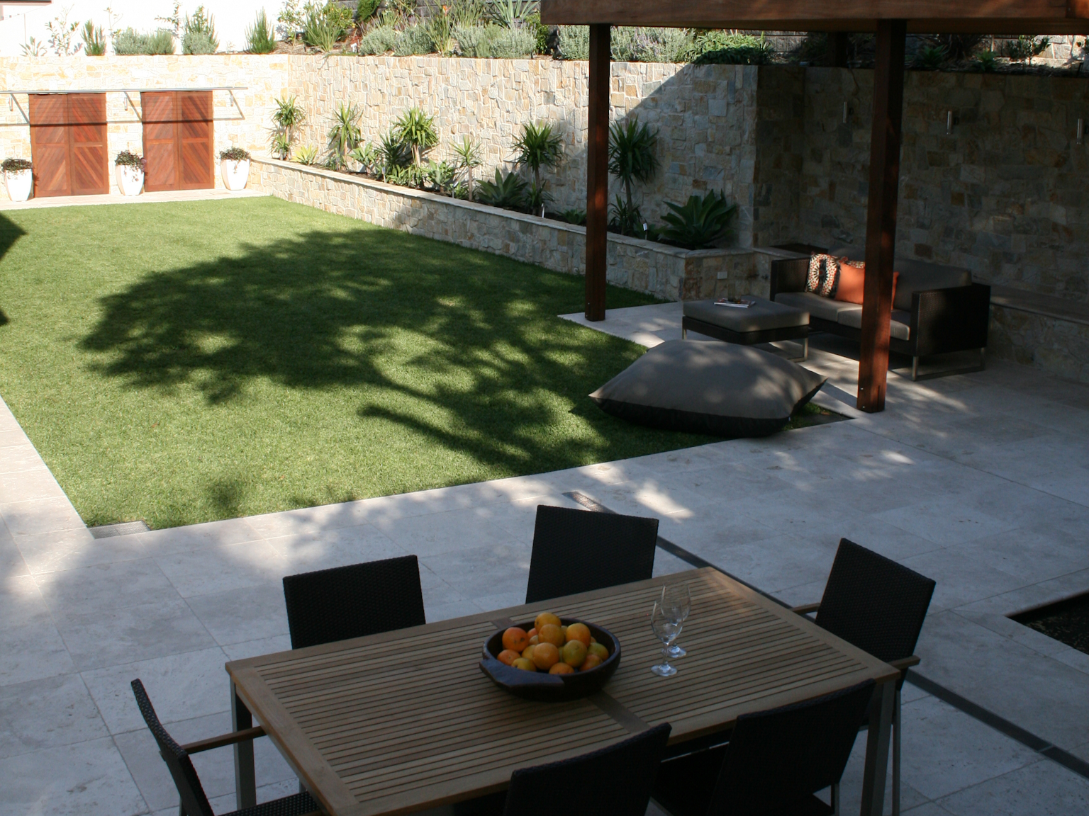 Paved area with outdoor dining setting surrounded by Coolum random ashlar walling