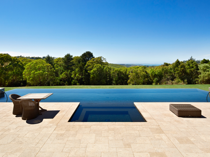 Infinity pool with expansive paving in Capri travertine modular format