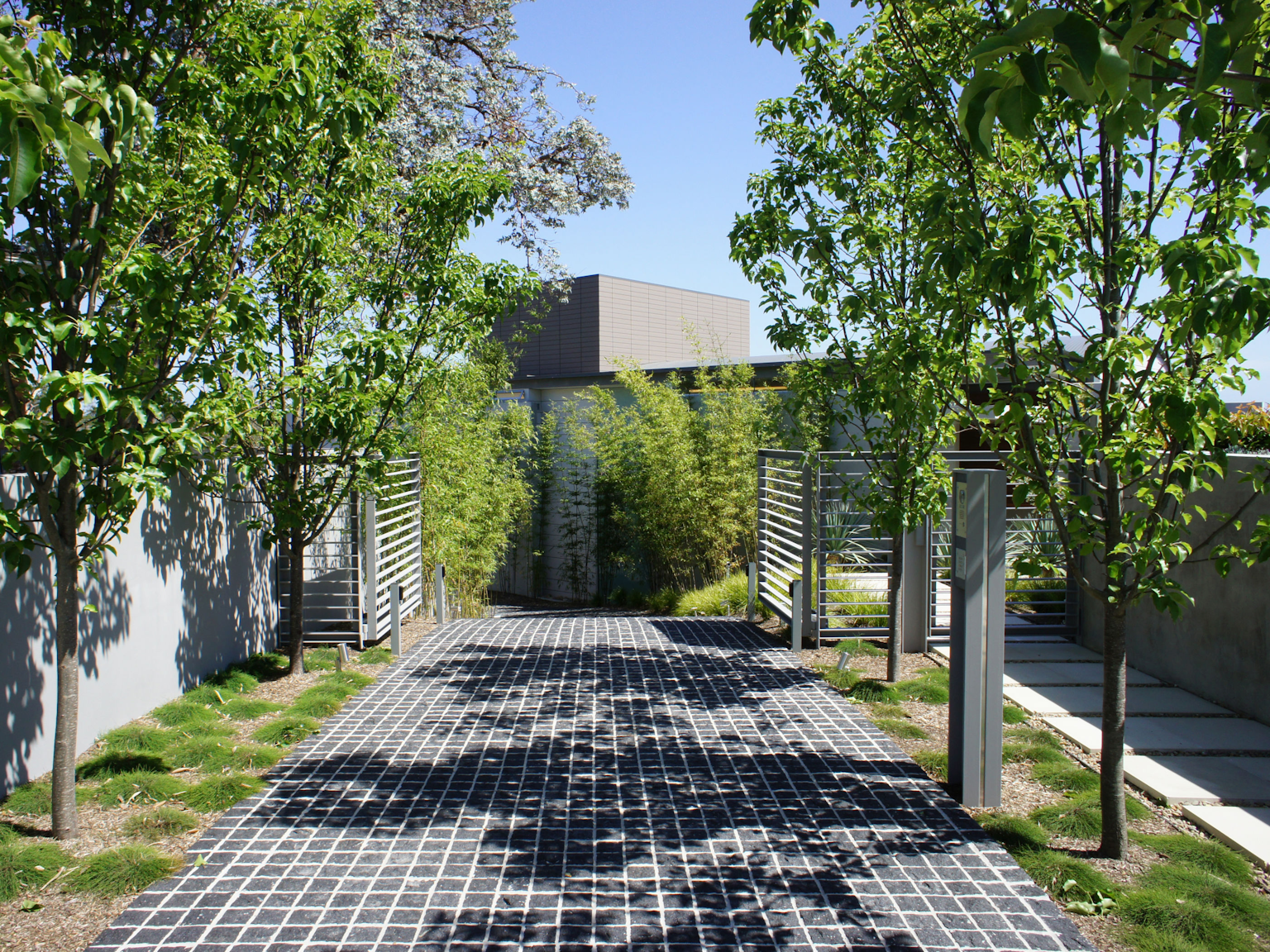 Driveway in split face Raven granite cobbles with pathway in Cashmere concrete pavers
