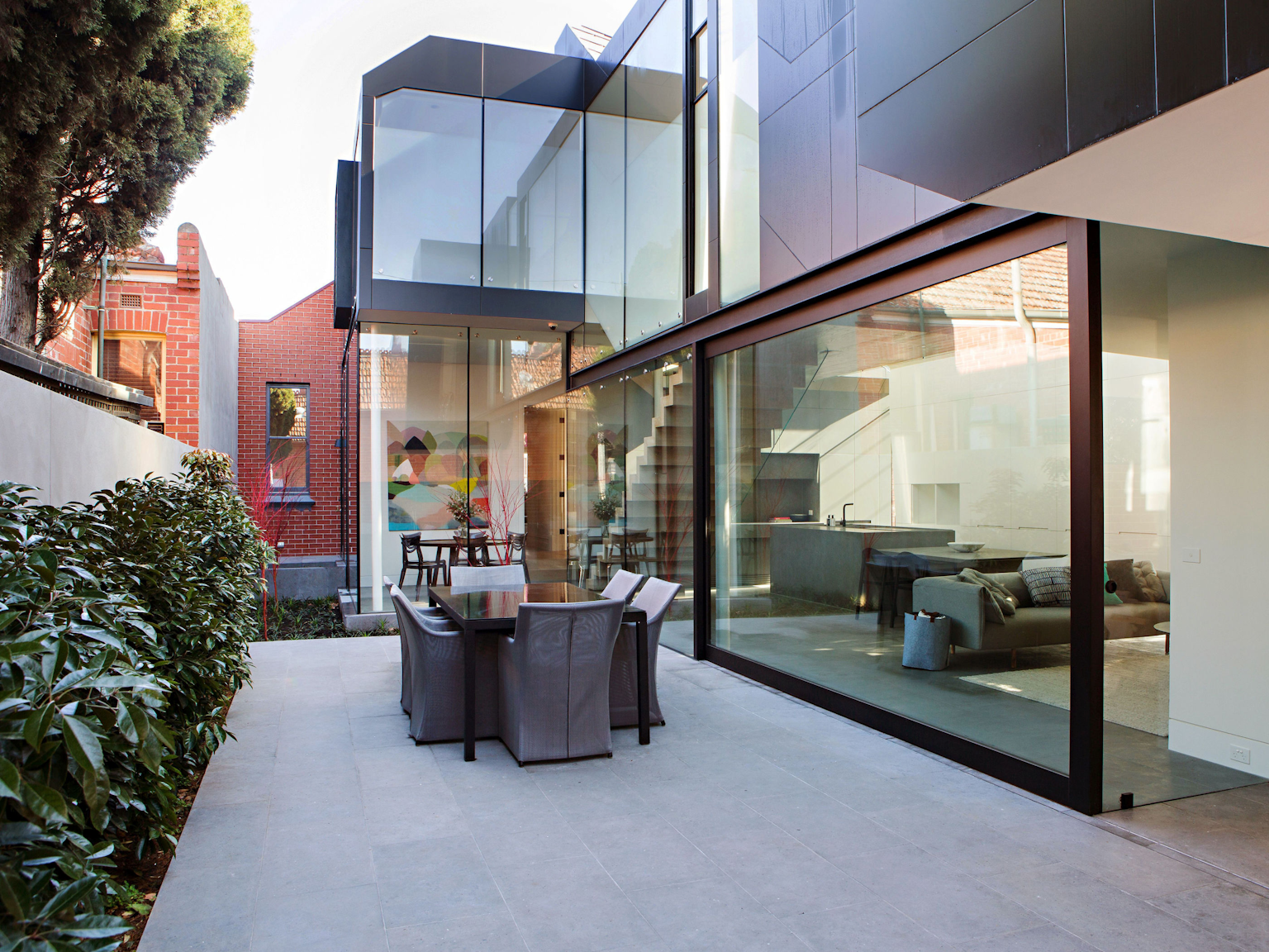 Natural stone used indoors and out in contemporary courtyard design.