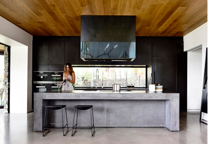 This material palette extends to the kitchen with a stunning concrete bench which defines the room