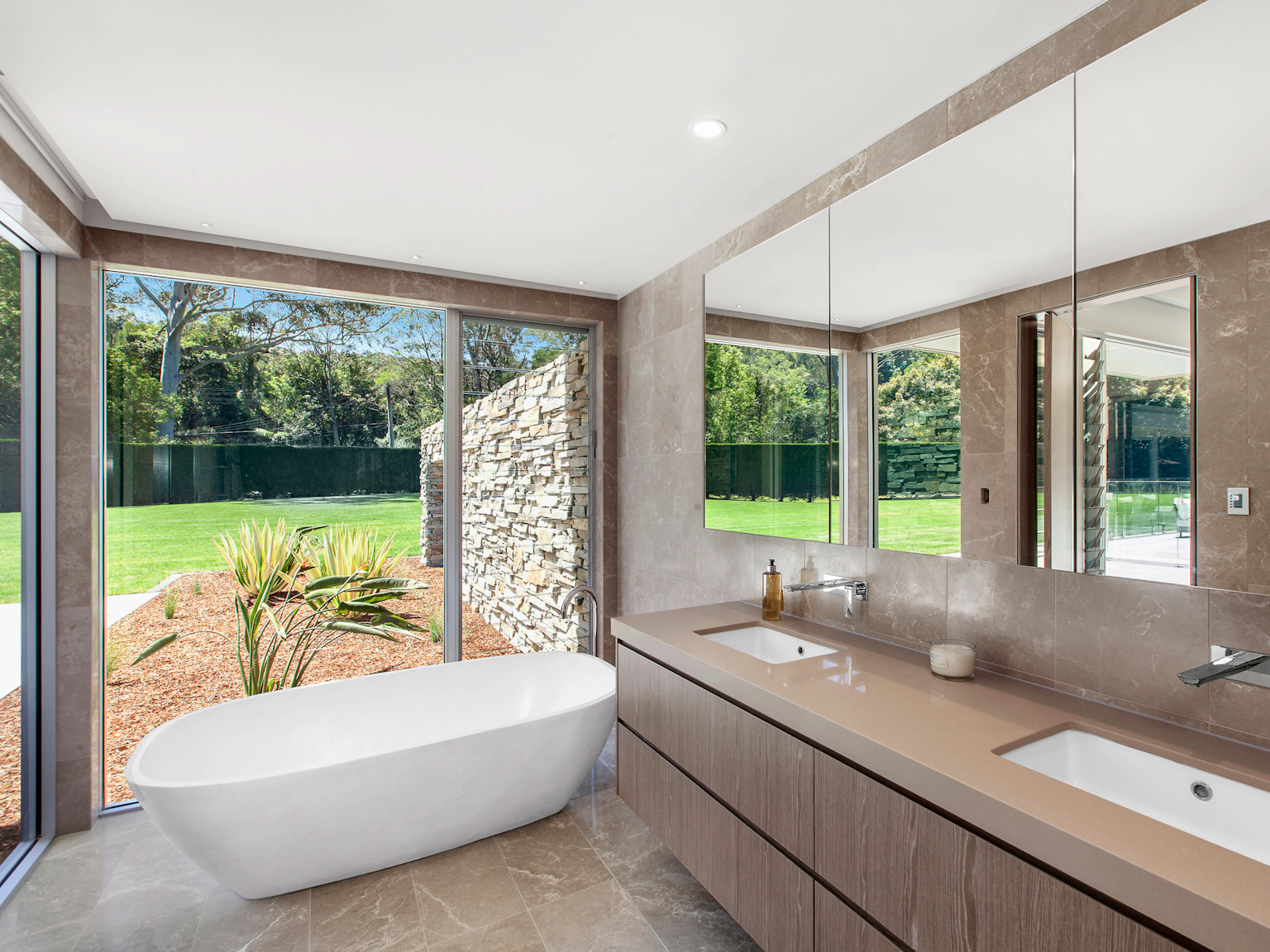 Bathroom with large blade wall clad in Baw Baw dry stone extending from external wall