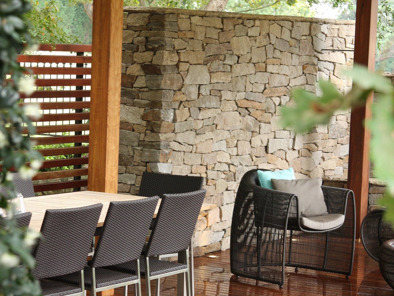 Alpine dry stone feature wall in entertainment area with wooden decking