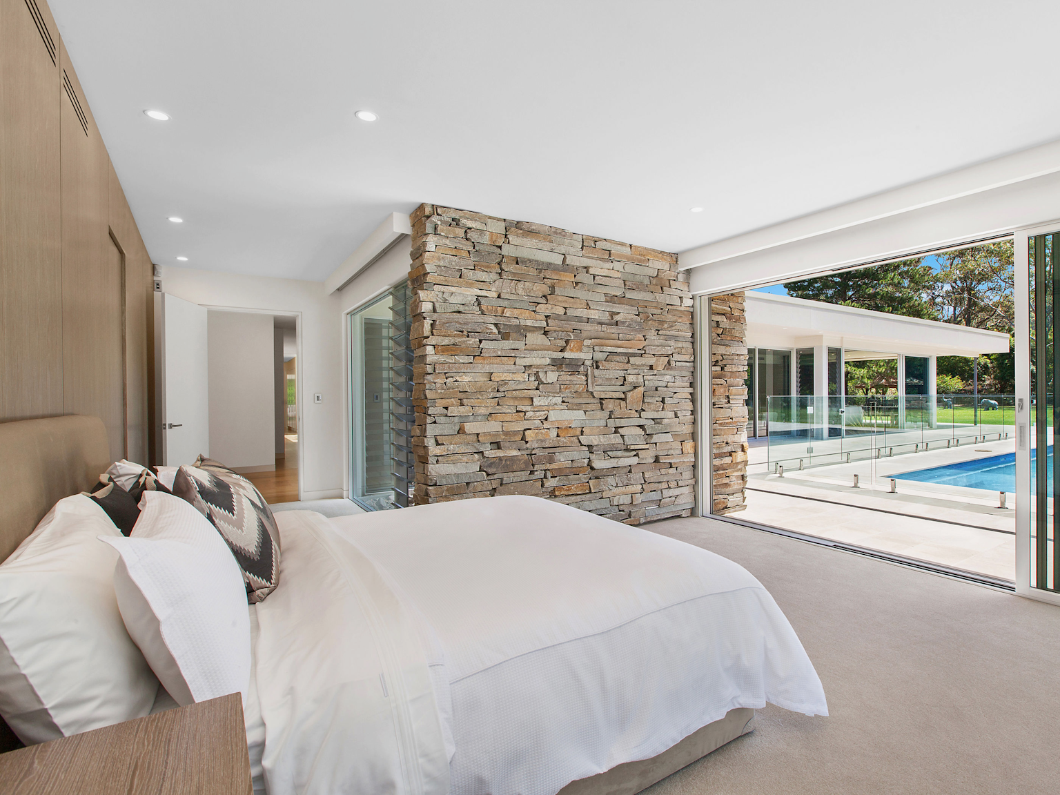View of master bedroom with Baw Baw dry stone feature wall projecting out toward pool area