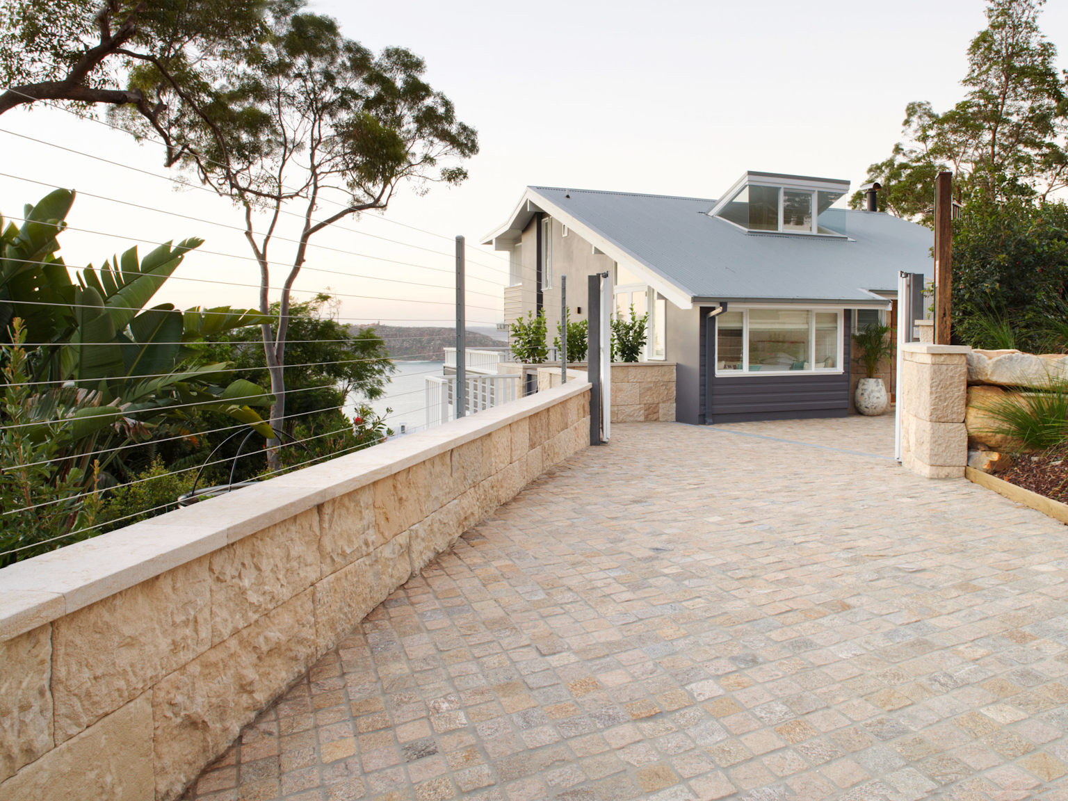 Sesame cobblestones line the driveway with a Barrimah traditional format retaining wall