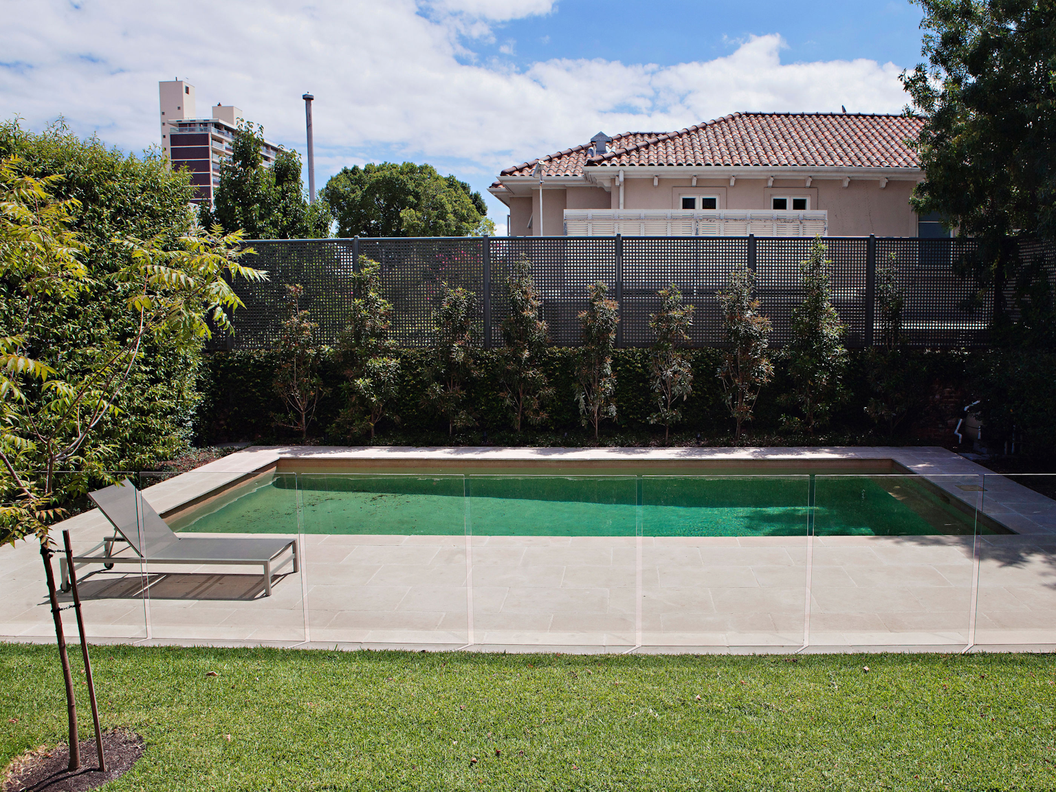 Rectangular pool surrounded by large format La Roche limestone pavers