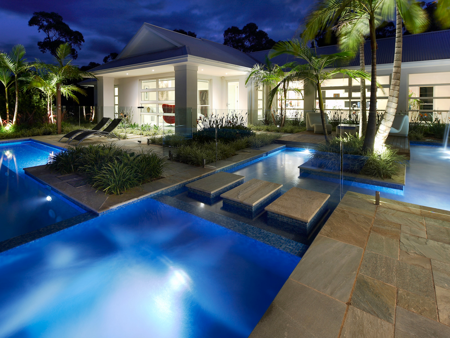 Resort style pool area with Cobb & Co split stone modular paving and stepping stones