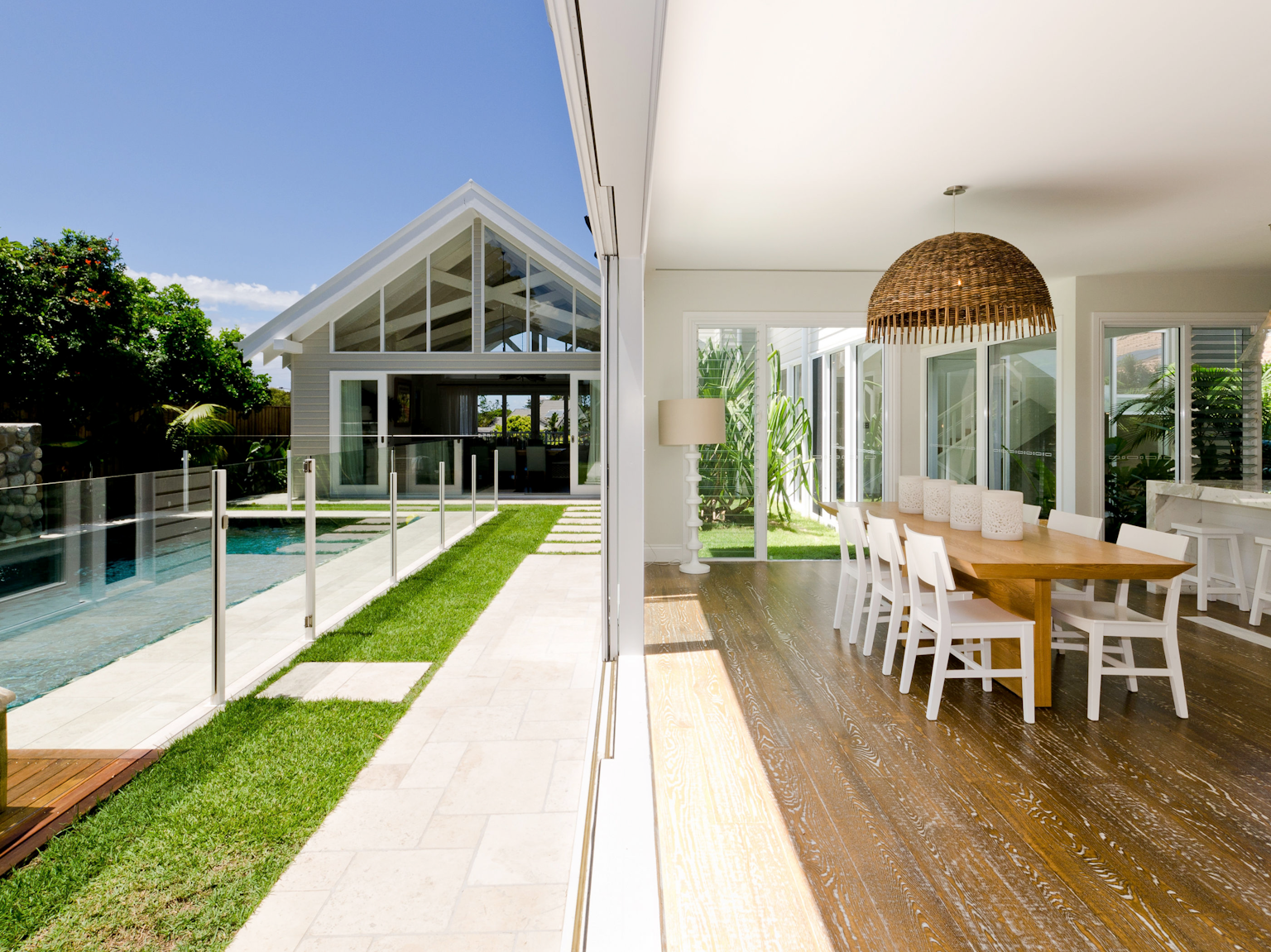 Pool surrounds and paving beside open plan kitchen using Ravello travertine modular paving